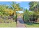 Charming wooden walkway surrounded by lush greenery and wrought iron fencing at 4707 Troydale Rd, Tampa, FL 33615