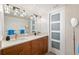 Modern bathroom with double sink vanity, stylish lighting, and a framed sliding glass door for the toilet at 5950 Pelican Bay S Plz # Ph-2F, Gulfport, FL 33707