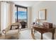 Bright bedroom with a comfy wicker chair and a sliding glass door to the balcony showcasing a beautiful view at 5950 Pelican Bay S Plz # Ph-2F, Gulfport, FL 33707
