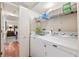 Convenient laundry room with washer, dryer, shelving, and bi-fold door to the hallway at 5950 Pelican Bay S Plz # Ph-2F, Gulfport, FL 33707