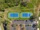 Overhead view of two well-maintained tennis courts, surrounded by greenery and a parking area at 5950 Pelican Bay S Plz # Ph-2F, Gulfport, FL 33707