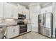 Contemporary kitchen featuring stainless steel appliances, granite counters, tile backsplash, and white cabinetry at 6007 Anchorage Way, St Petersburg, FL 33712
