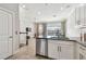 Modern kitchen with stainless steel dishwasher and sleek countertops leads to an inviting living area at 6007 Anchorage Way, St Petersburg, FL 33712