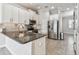 Updated kitchen features white cabinets, granite countertops, stainless appliances, and tile flooring at 6007 Anchorage Way, St Petersburg, FL 33712