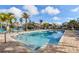 A refreshing community pool with an easy step-in entry, surrounded by lush landscaping and clear blue sky at 6007 Anchorage Way, St Petersburg, FL 33712