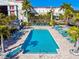 A sunny aerial view of a community pool area with palm trees and lounge chairs at 6007 Anchorage Way, St Petersburg, FL 33712