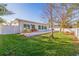 Backyard featuring a concrete patio, lawn, tropical trees and white fence at 6101 Tanglewood Ne Dr, St Petersburg, FL 33703