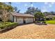 Exterior shot of the home's three-car garage and brick driveway surrounded by green landscaping at 632 Royal Dornock Ct, Tarpon Springs, FL 34688