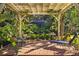 Relaxing outdoor seating area underneath a white pergola with a black patio umbrella at 632 Royal Dornock Ct, Tarpon Springs, FL 34688