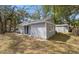 Exterior view of a gray home with trees, a green lawn, and a small outbuilding at 6802 N 15Th St, Tampa, FL 33610