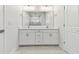 Bathroom features a double sink vanity with large mirror, quartz countertops, and tile flooring at 7213 Sutton Ln, Sarasota, FL 34240