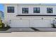Modern townhome showcases attached two car garage and bright white facade at 7213 Sutton Ln, Sarasota, FL 34240