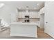 Bright white kitchen featuring a large island with a sink and stainless steel appliances at 7213 Sutton Ln, Sarasota, FL 34240