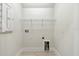 Bright laundry room features tile flooring, wire shelving and utility connections at 7213 Sutton Ln, Sarasota, FL 34240