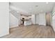 Open-concept living space with modern kitchen, white cabinets, stainless appliances, and wood-look floors at 7213 Sutton Ln, Sarasota, FL 34240