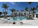 Community pool with lounge chairs and striped umbrellas at 7213 Sutton Ln, Sarasota, FL 34240