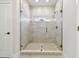 Luxurious bathroom shower featuring stylish tilework, a frameless glass door, and a convenient window at 7213 Sutton Ln, Sarasota, FL 34240
