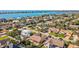 Gorgeous aerial shot showcases a peaceful residential area with homes with pools near the ocean, and lush trees and landscaping at 725 Monte Cristo Blvd, Tierra Verde, FL 33715