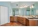 Light-filled bathroom with large mirror, double sink vanity, and walk in shower at 725 Monte Cristo Blvd, Tierra Verde, FL 33715