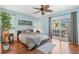 Bedroom with hardwood floors, ceiling fan, and sliding glass doors to lanai at 725 Monte Cristo Blvd, Tierra Verde, FL 33715