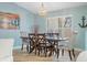 Light-filled dining area with wood table, decorative chandelier, and bright windows at 725 Monte Cristo Blvd, Tierra Verde, FL 33715