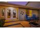 Inviting home entrance with double glass doors, colorful decor, a cozy sitting area, and manicured landscaping at 725 Monte Cristo Blvd, Tierra Verde, FL 33715