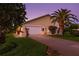 Inviting exterior view of a well-maintained home with a lush lawn, palm trees, and an attached garage at 725 Monte Cristo Blvd, Tierra Verde, FL 33715