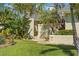 Charming home featuring tropical landscaping and manicured lawn leading to a private front entrance at 725 Monte Cristo Blvd, Tierra Verde, FL 33715