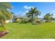 Expansive front lawn with lush green grass and mature palm trees surrounding the property at 725 Monte Cristo Blvd, Tierra Verde, FL 33715