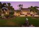 Well-manicured front yard with lush lawn, tropical plants, and attractive mailbox at dusk at 725 Monte Cristo Blvd, Tierra Verde, FL 33715