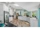 Spacious eat-in kitchen with stainless steel appliances, white cabinets, and a stylish tile backsplash at 725 Monte Cristo Blvd, Tierra Verde, FL 33715
