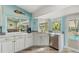 Bright kitchen featuring white cabinets, a corner sink with a view, and stainless steel appliances at 725 Monte Cristo Blvd, Tierra Verde, FL 33715