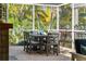 Covered lanai with dining table and chairs, and views of lush backyard at 725 Monte Cristo Blvd, Tierra Verde, FL 33715