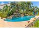 Stunning backyard pool features a rock waterfall, lush landscaping, and a spacious patio for outdoor enjoyment at 725 Monte Cristo Blvd, Tierra Verde, FL 33715
