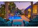 A stunning backyard pool with a waterfall and lush tropical landscaping viewed from the covered lanai at 725 Monte Cristo Blvd, Tierra Verde, FL 33715