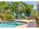 Charming poolside seating area with stylish lounge chairs, overlooking the pool, spa and lush landscaping at 725 Monte Cristo Blvd, Tierra Verde, FL 33715