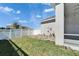 Well-maintained backyard featuring green grass, a white fence, and a paved area for outdoor relaxation at 729 Winterside Dr, Apollo Beach, FL 33572