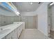 Bright bathroom featuring double vanity, framed mirrors, and glass-enclosed shower at 729 Winterside Dr, Apollo Beach, FL 33572