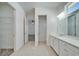 Bathroom featuring tile floors, white cabinets, and a large mirror at 729 Winterside Dr, Apollo Beach, FL 33572