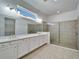 Bright bathroom featuring double vanity, framed mirrors, and glass-enclosed shower at 729 Winterside Dr, Apollo Beach, FL 33572