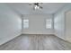 Bright bedroom featuring sleek gray flooring, a ceiling fan, and natural light from shuttered windows at 729 Winterside Dr, Apollo Beach, FL 33572