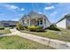 Well-manicured front yard and charming exterior of a single-story home with a covered front porch at 729 Winterside Dr, Apollo Beach, FL 33572
