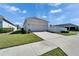 Exterior view of home with a paved driveway, two-car garage, and manicured lawn at 729 Winterside Dr, Apollo Beach, FL 33572