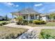 Charming single-story home with a welcoming front porch, lush landscaping, and a well-manicured lawn at 729 Winterside Dr, Apollo Beach, FL 33572