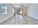 Bright living room featuring wood-look tile floors, modern ceiling fan, and sliding glass doors to the patio at 729 Winterside Dr, Apollo Beach, FL 33572