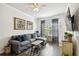 Cozy living room featuring a comfortable gray sofa, dark wood floors, and bright natural light at 800 S Dakota Ave # 217, Tampa, FL 33606