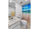 Functional bathroom with a toilet, vanity, and shower with beach-themed curtain at 808 Bahia Del Sol Dr # 14, Ruskin, FL 33570