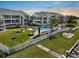 A waterfront condo complex with a pool, a green lawn, palm trees, and a surrounding fence at 808 Bahia Del Sol Dr # 14, Ruskin, FL 33570