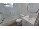 Bright bathroom featuring a bathtub with a glass shower door and white vanity at 8416 Redfield Dr, Port Richey, FL 34668