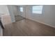 Bright bedroom featuring wood-look flooring, mirrored closet doors, and a window providing natural light at 8416 Redfield Dr, Port Richey, FL 34668